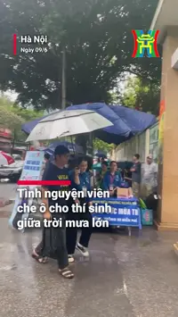 Tình nguyện viên che ô cho thí sinh giữa trời mưa